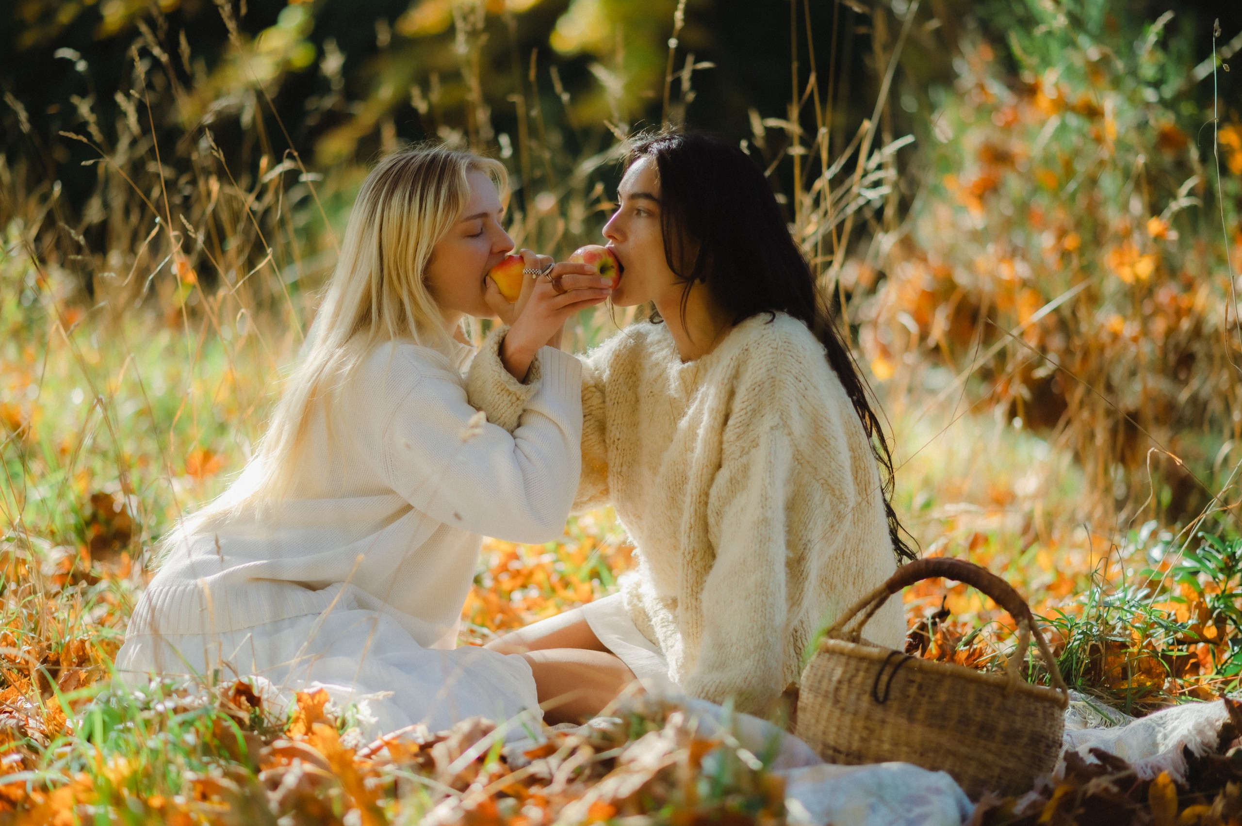 Friends sharing apples in the orchard
