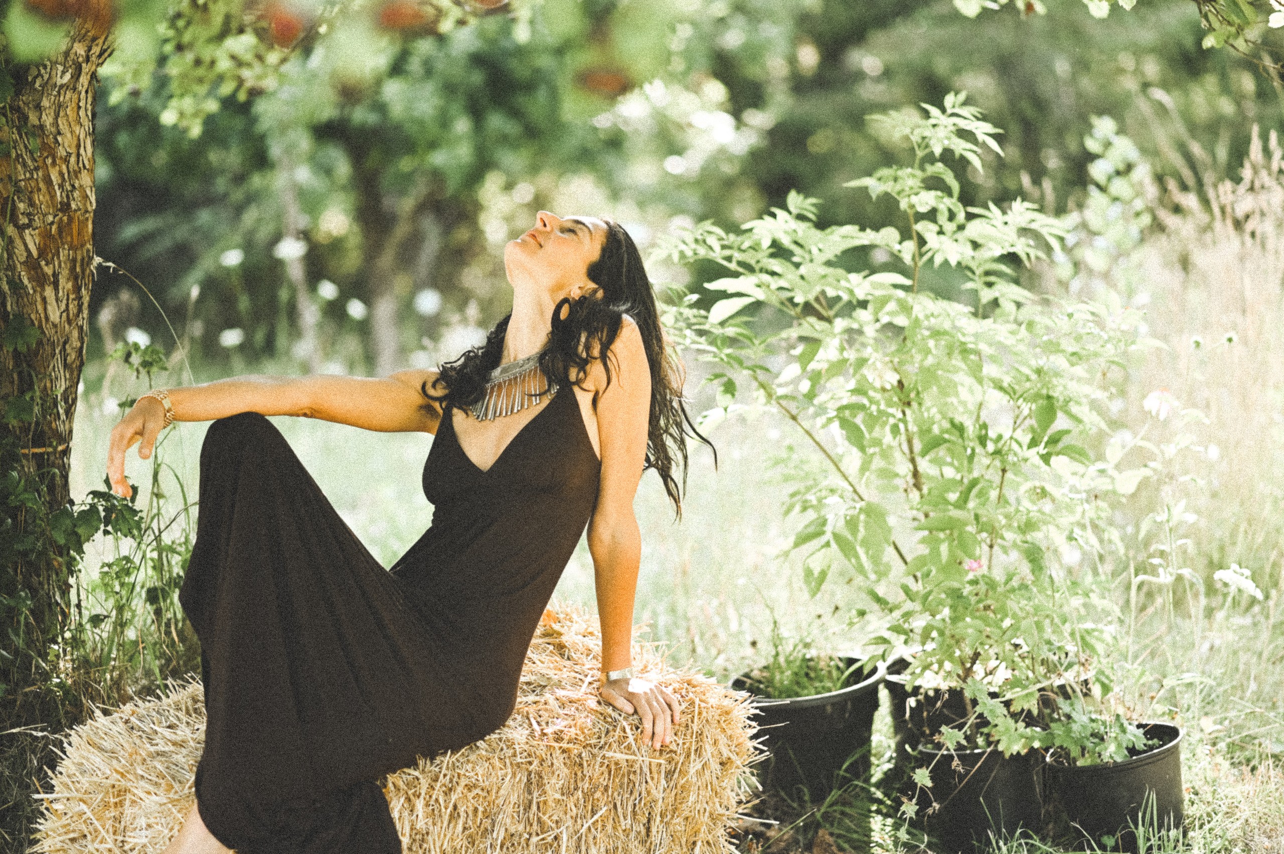 Portrait in black dress on haybale